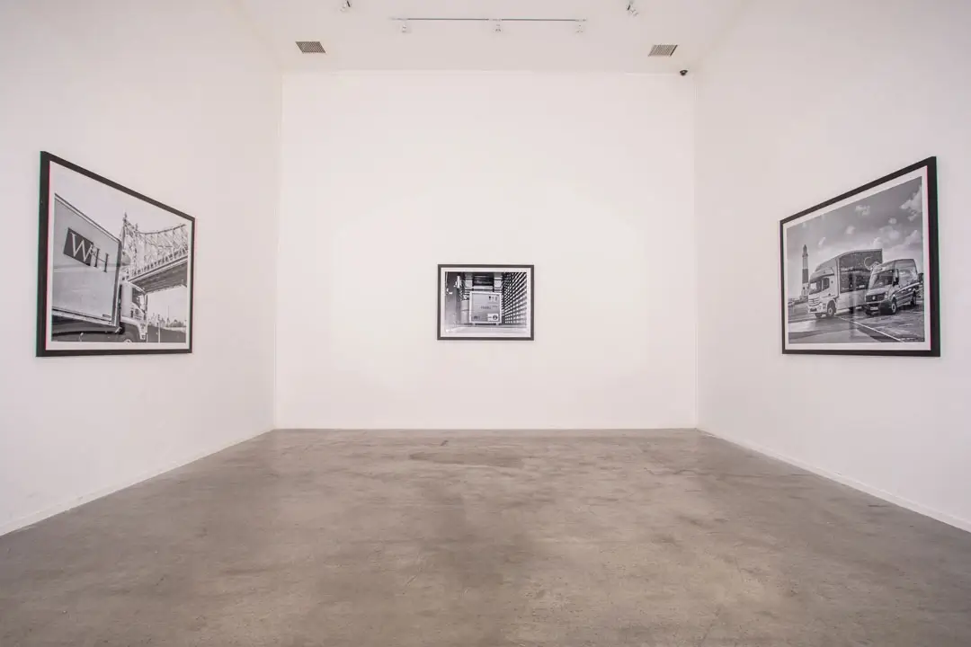 Framed artwork installation on three connecting white walls