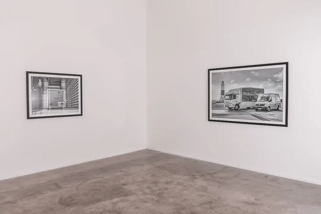 Framed artwork installation on two connecting white walls at angle of corner